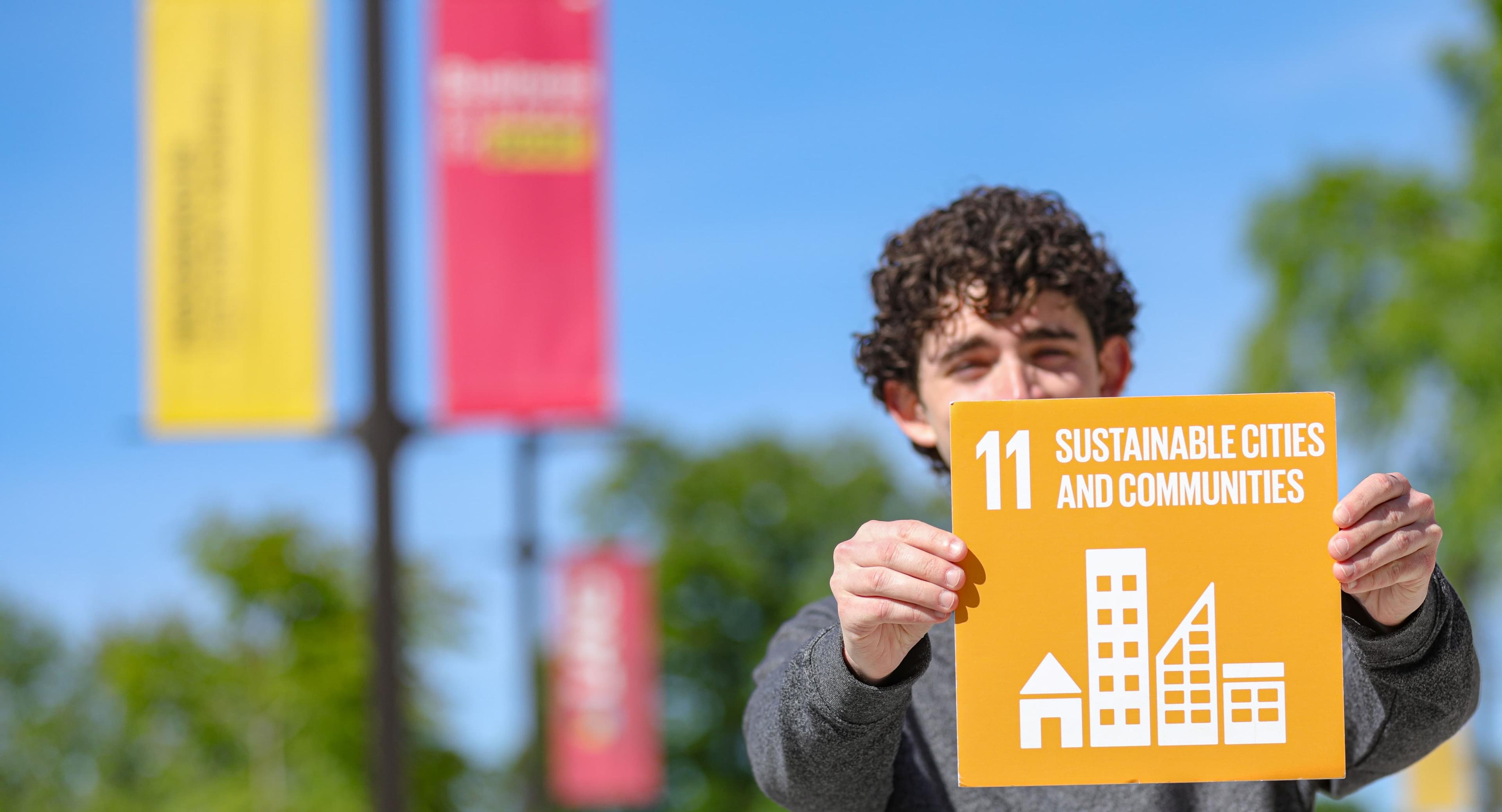 Man holding an SDG sign