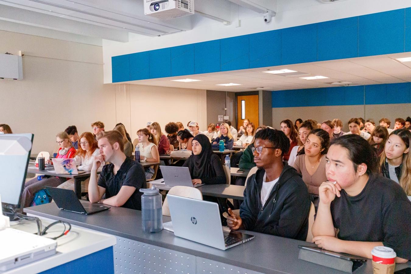 Classroom of chemistry students attentively listening to professor.