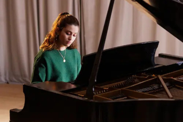 A student playing a piano