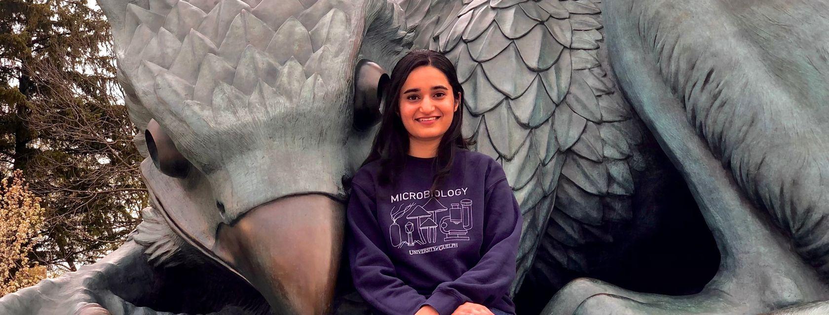 Parneet Kaur Sitting in front of the Gryphon statue.