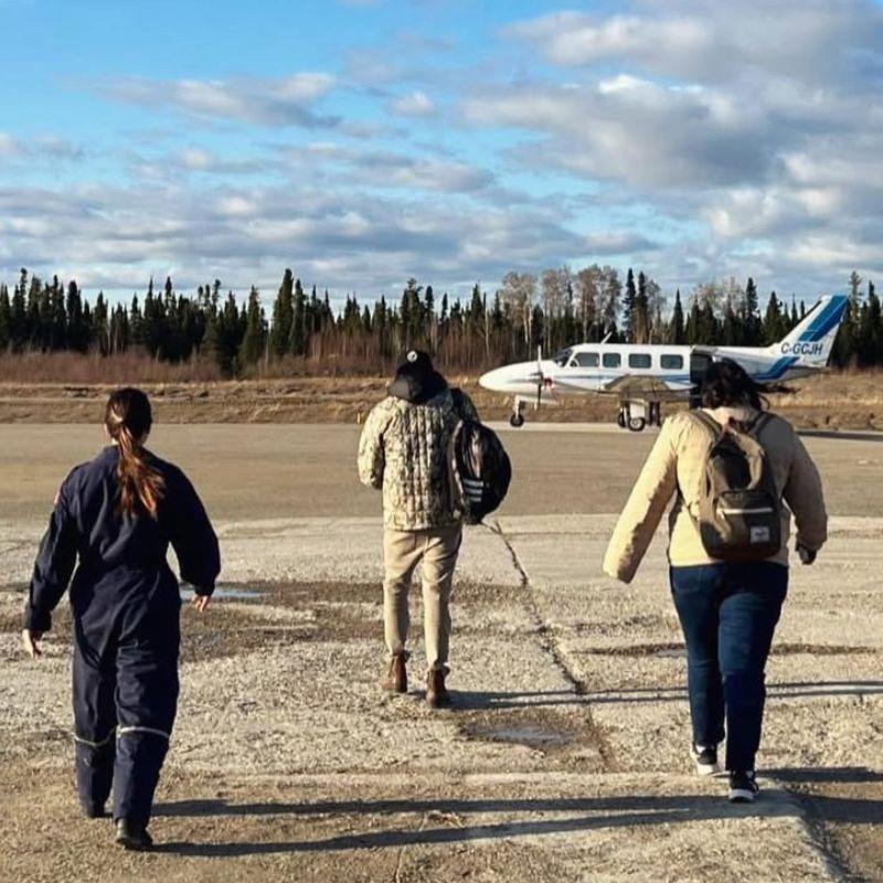 3 individuals walking towards a small private plane.