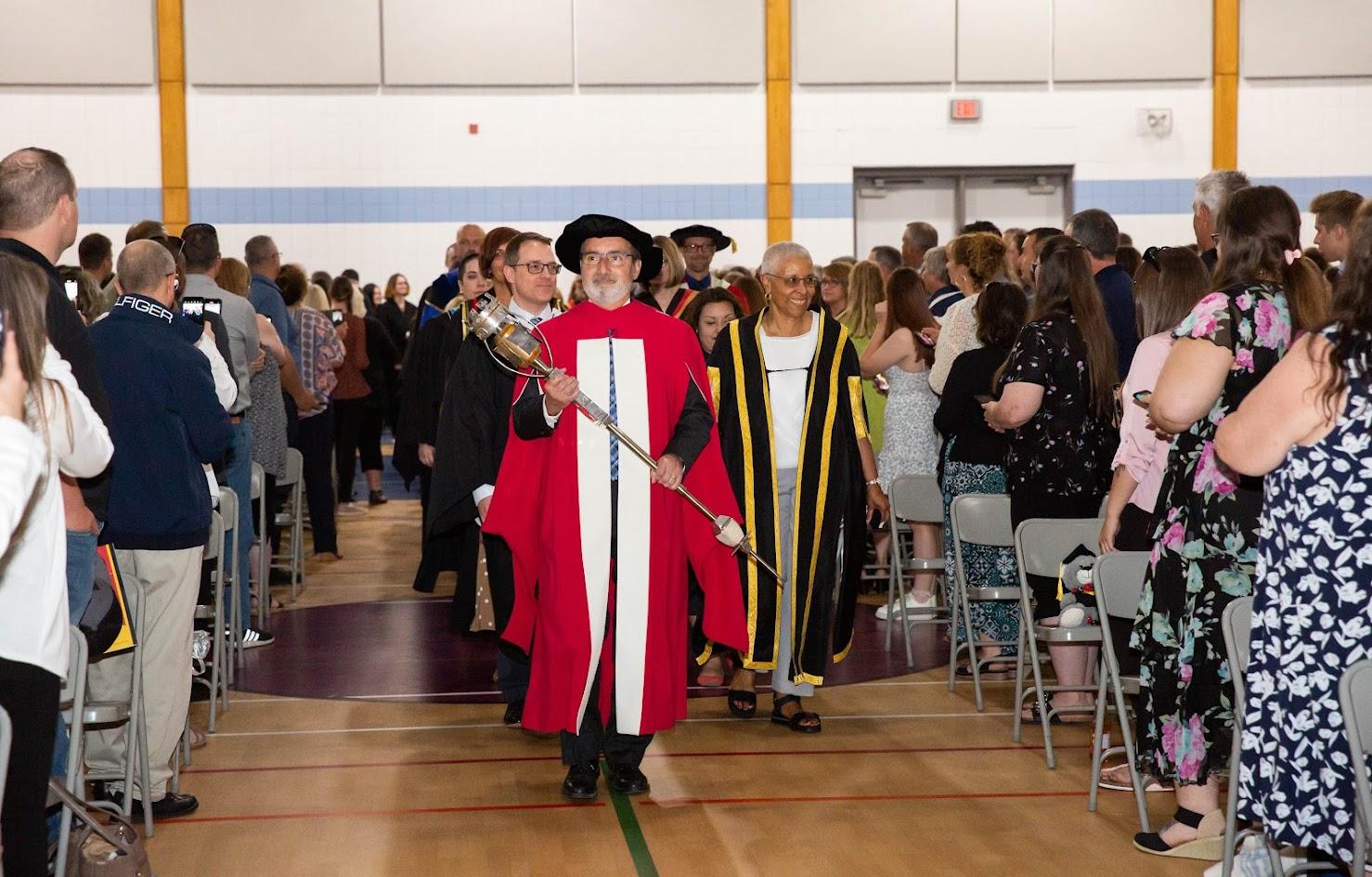 Dignitaries walking down aisle at convocation.