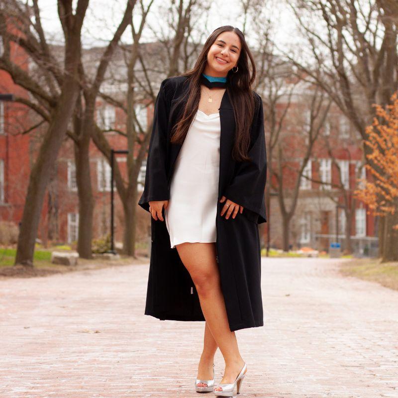 Lauren Yee posing on campus in the fall in her grad gown