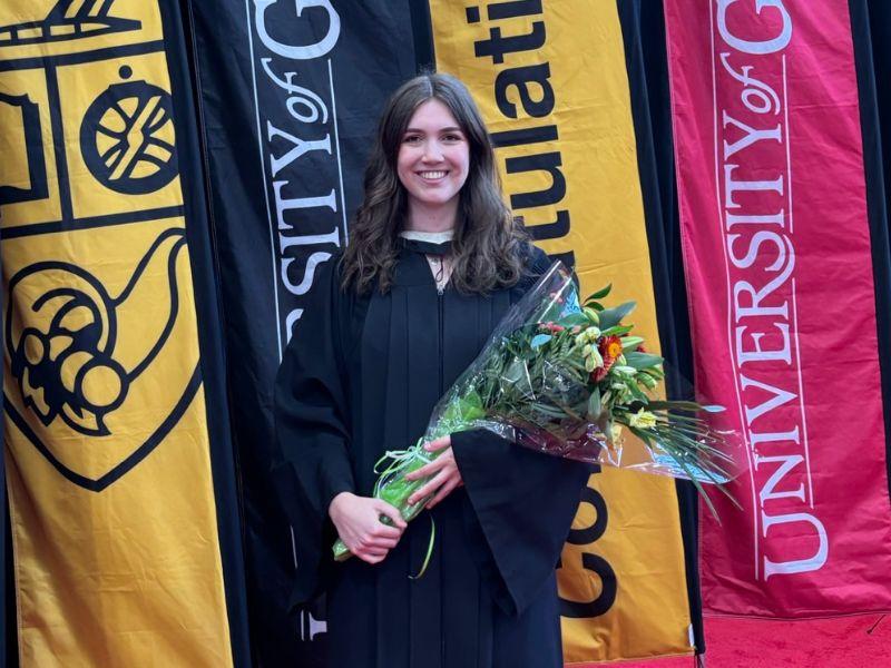 Guelph Grad Abigail Boorsma holding flowers at her graduation. 