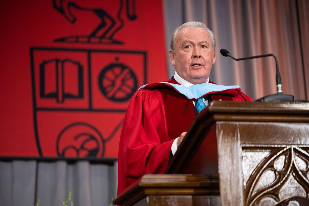A person speaking at a podium on a stage