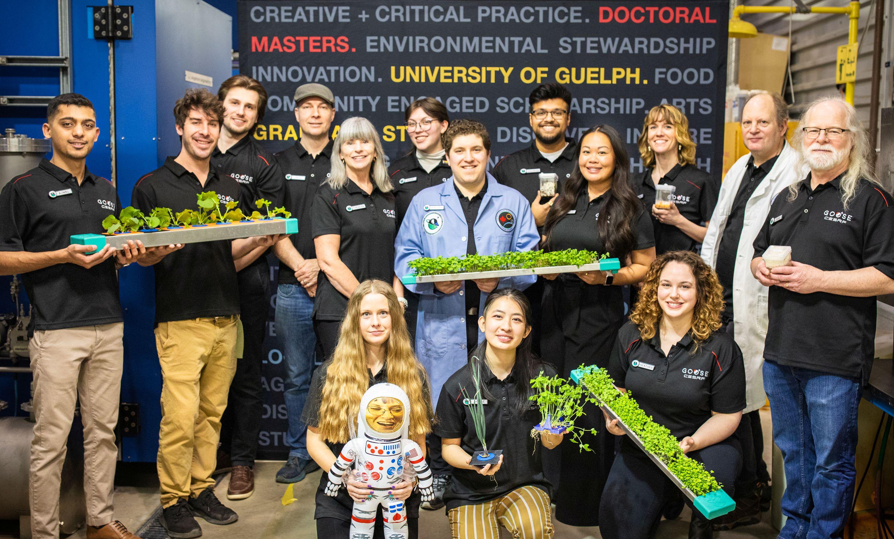 Members of Guelph's Controlled Environment Agriculture research group stand in front of a UofG banner, smiling. 