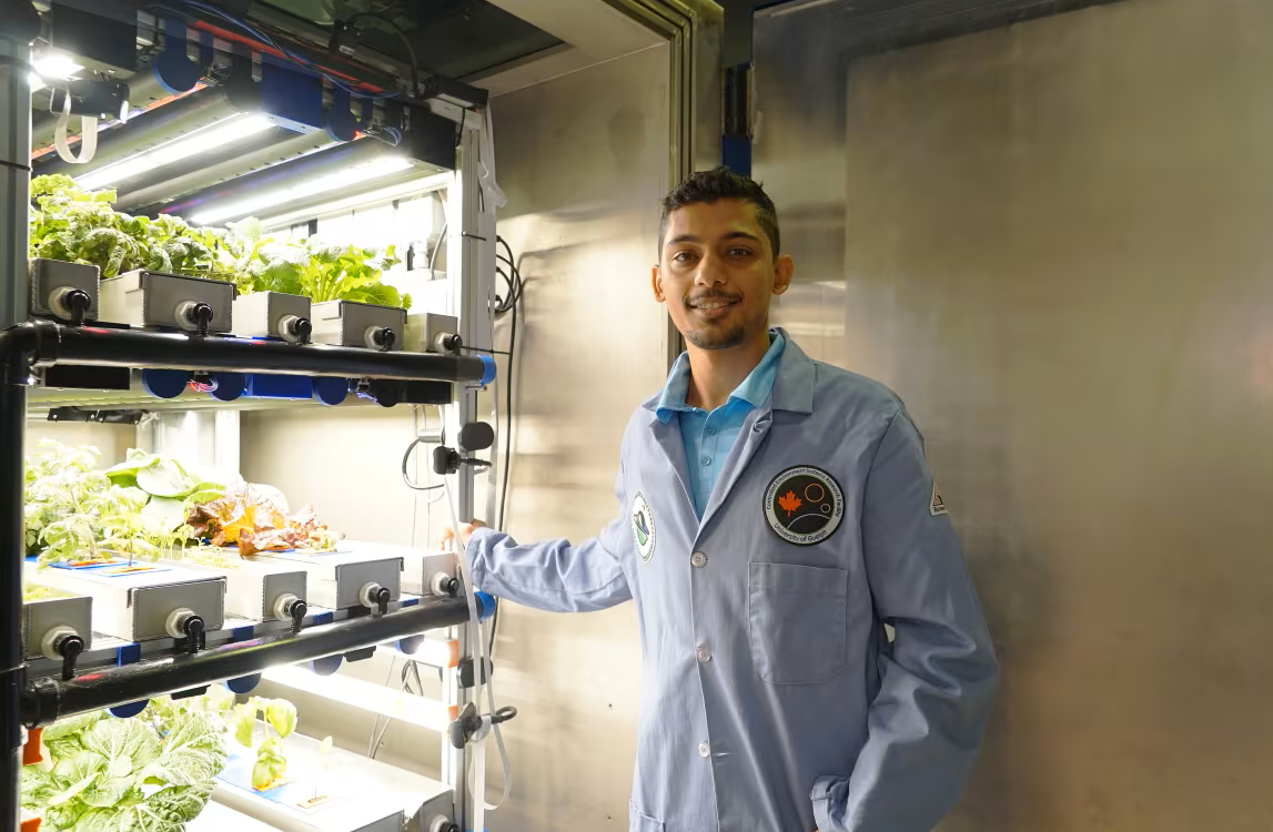 ajwal standing in front of plants grown indoors