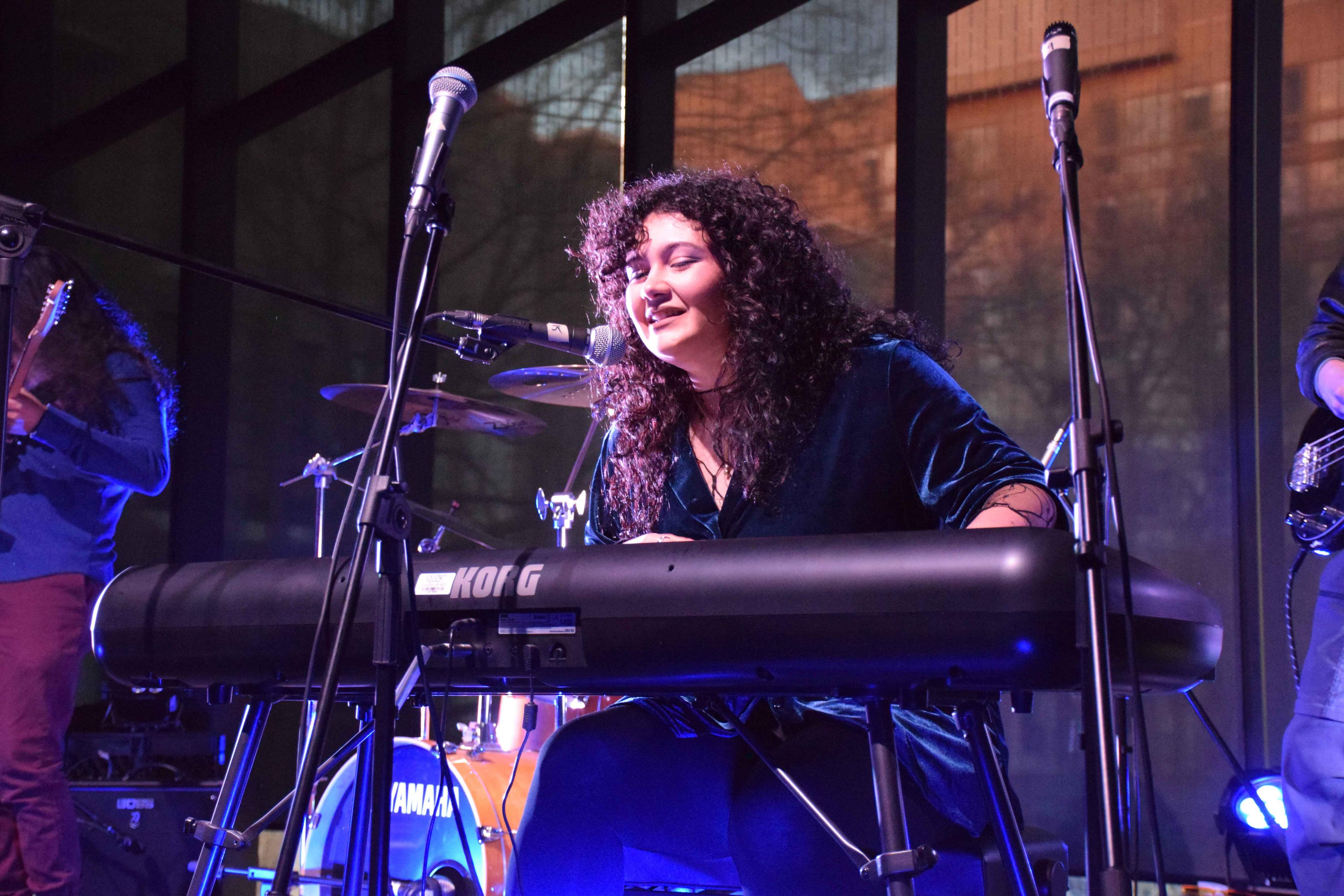 Student playing the keyboard and singing. 