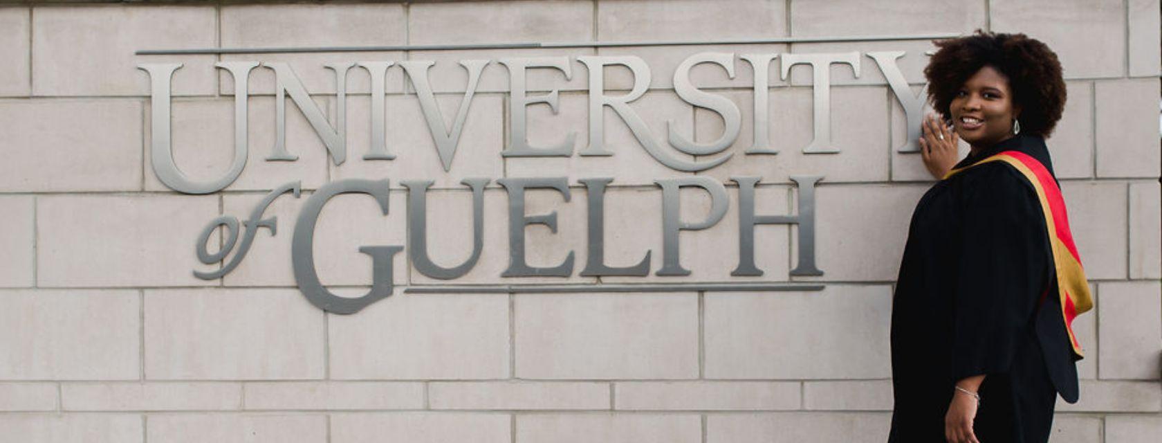Guelph Grad Kia-Marie Parsons stands in front of the U of G sign at her convocation