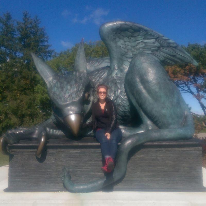 Dr. Mikaela D. Gabriel poses with the Gryphon statue 