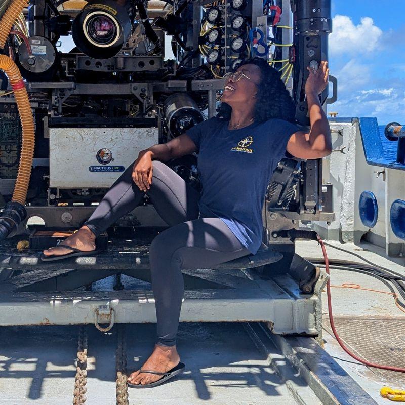 Moronke Harris sitting with a deep-sea submersible. 