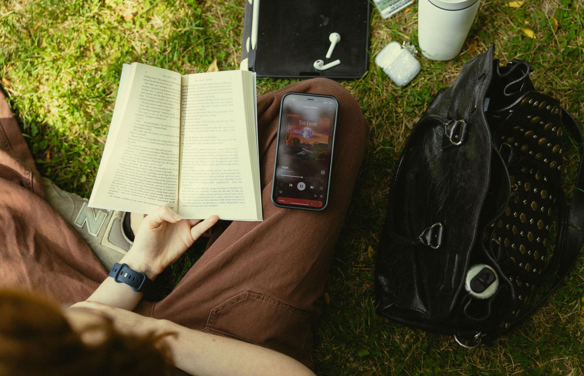 Photo of students lap reading a book and listening to music