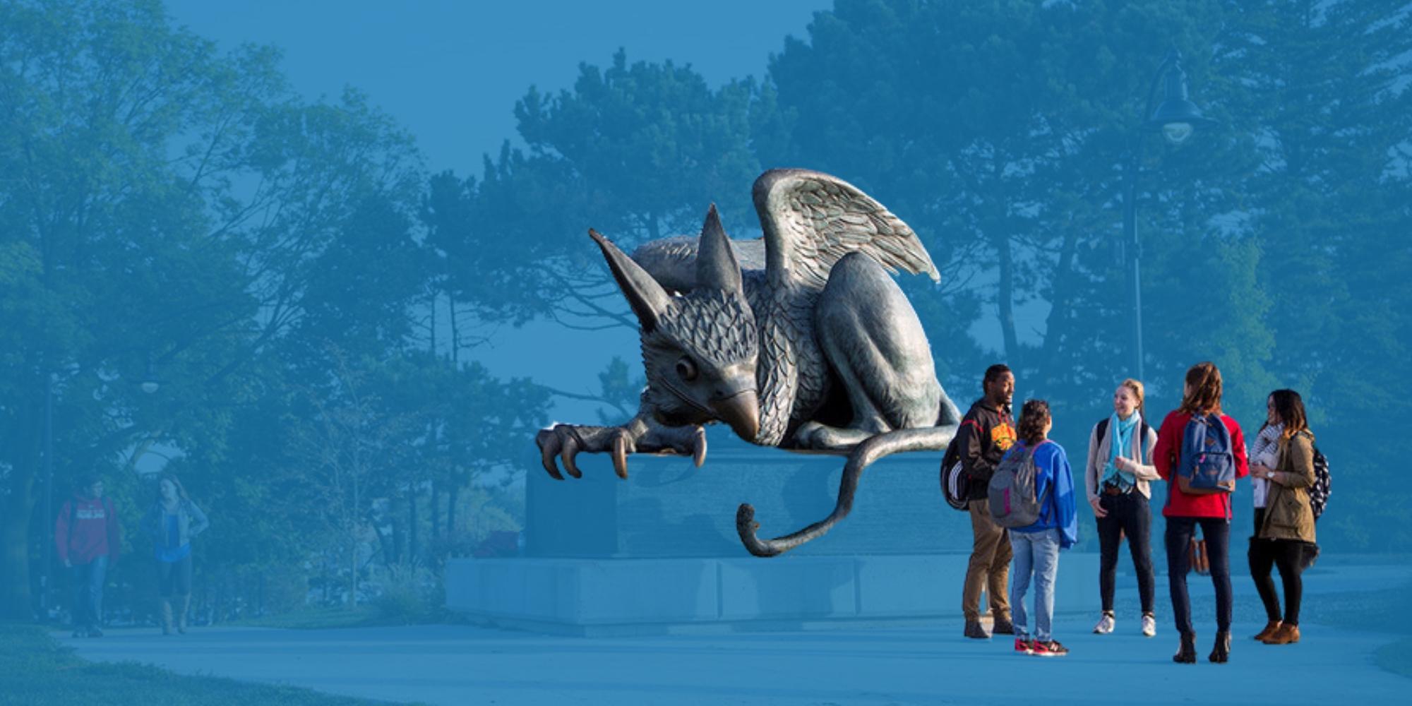 Five students hanging out in front of Gryphon statue with blue background