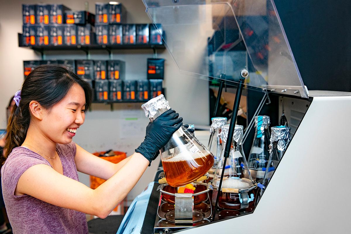Woman boiling liquid in beaker