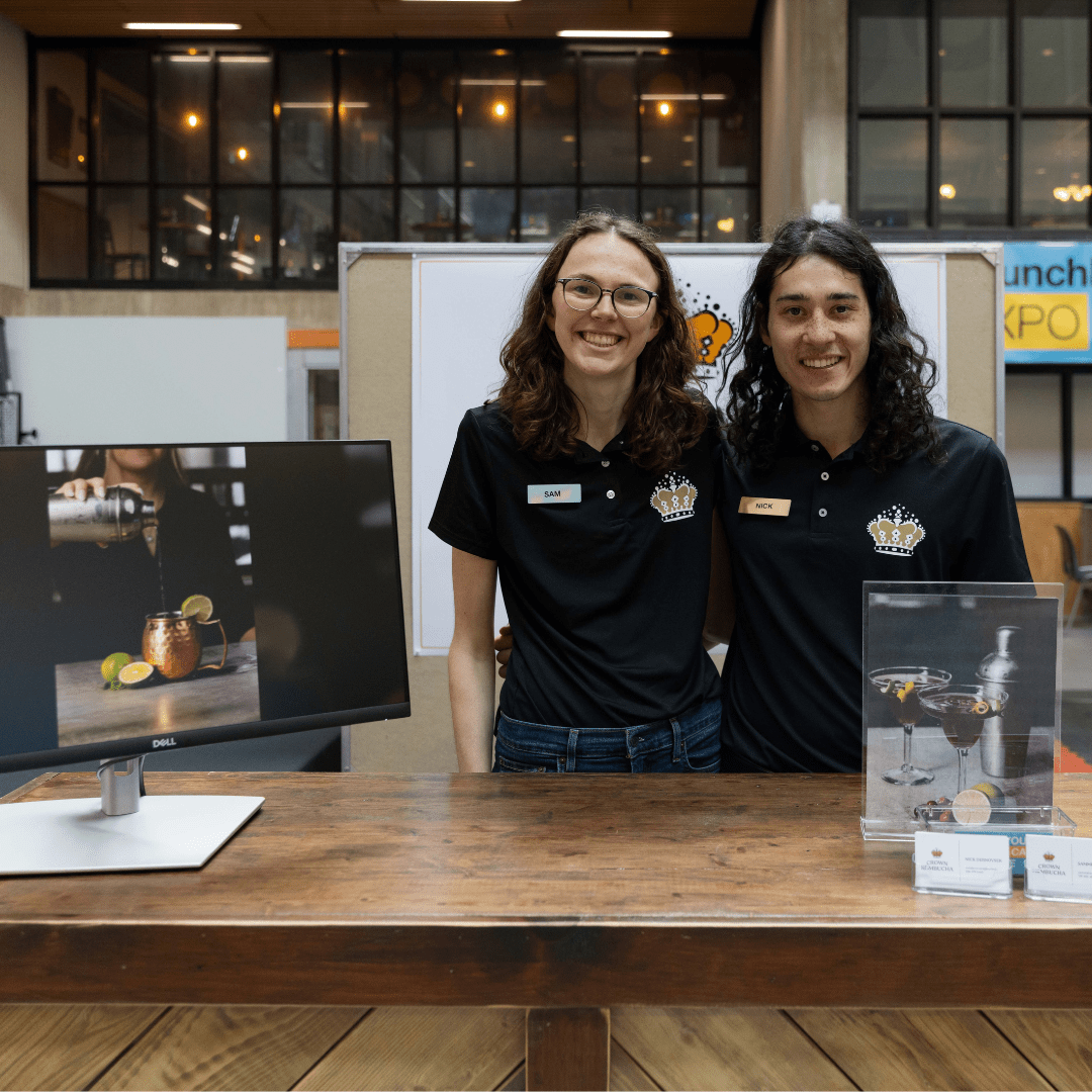 Two individuals behind booth at LaunchLab Expo Event