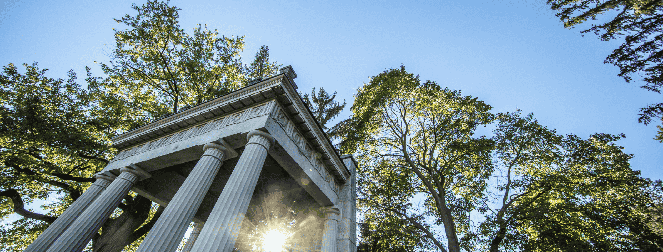 campus portico with trees and blue sky