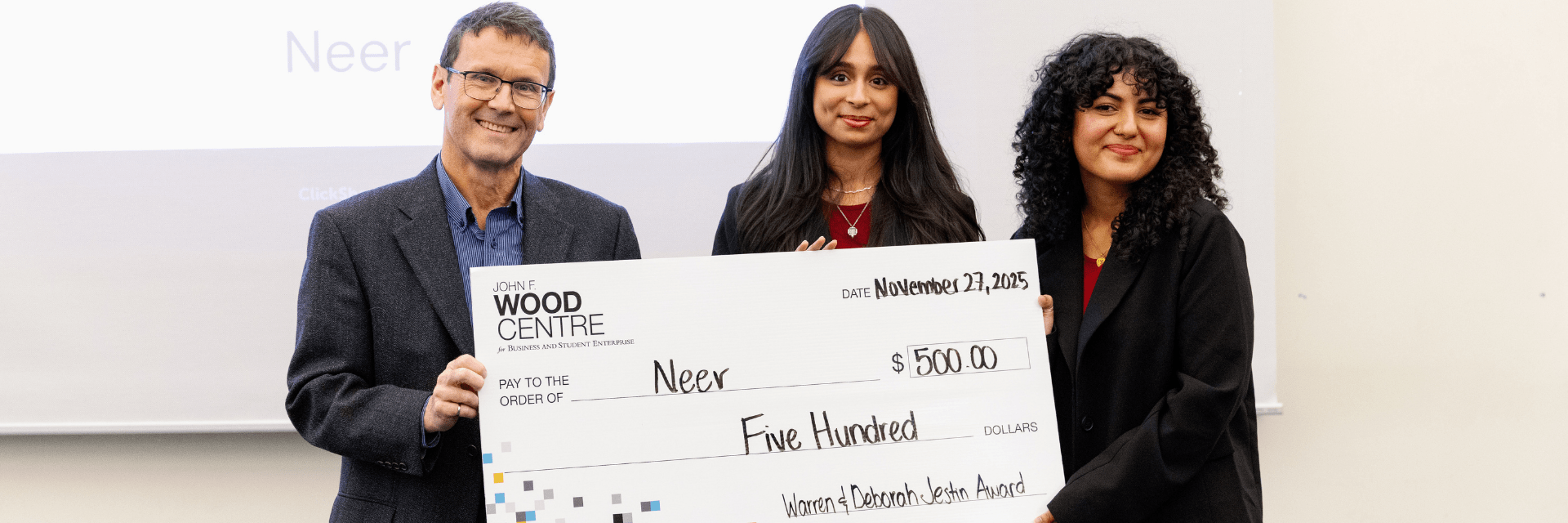 3 individuals holding cheque