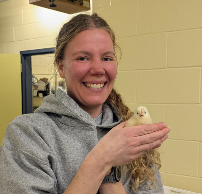 Lea holding a baby chick in her hand
