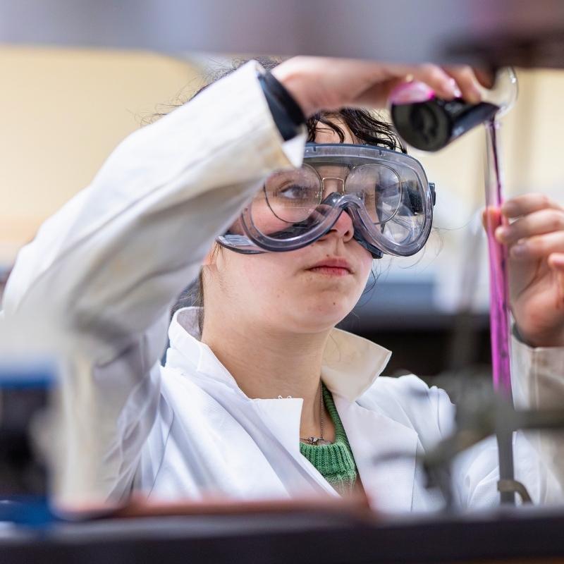 Student pouring into a tube