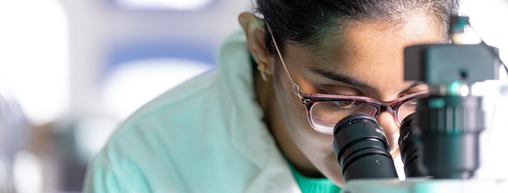 Student looking through a microscope