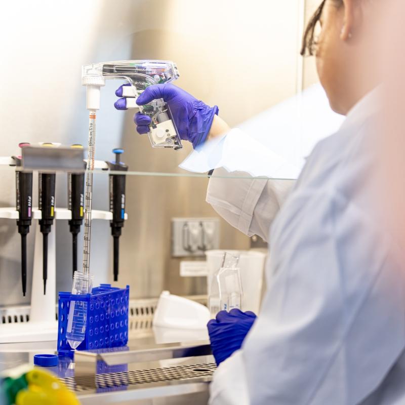 Student pipetting in a hood