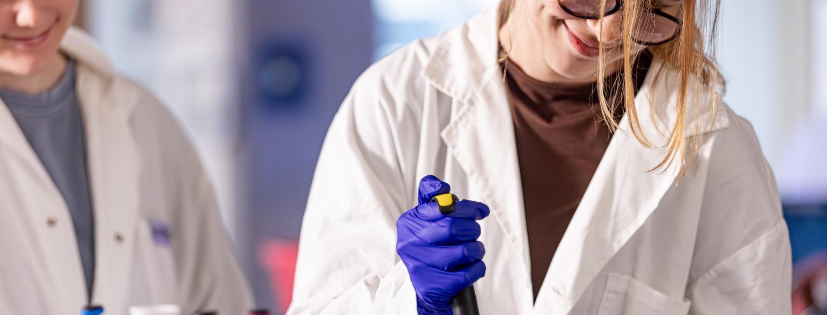 Student pipetting next to instructor