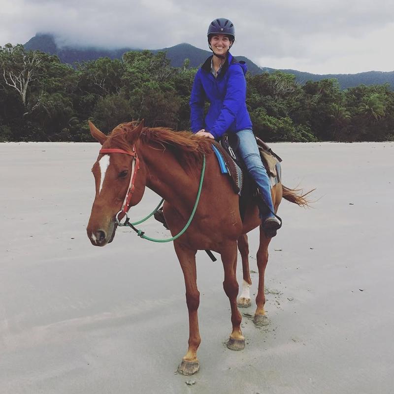 Young woman riding a horse on the beach.
