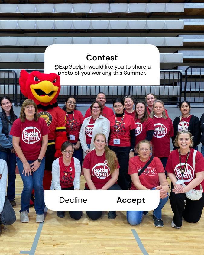 Gryph stands in a gym with a group of people wearing red shirts, posting for a photo. Contest: @ExpGuelph would like you to share a photo of you working this Summer.