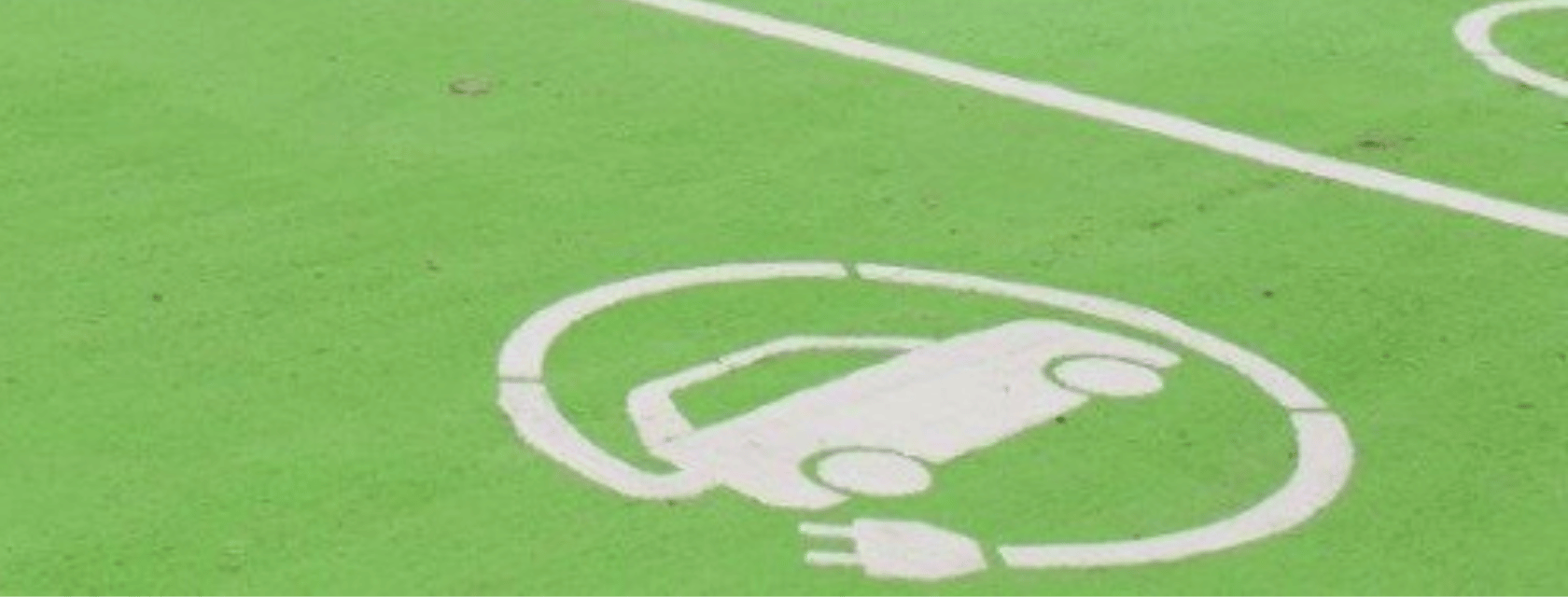 a green parking space with the symbol for e-charging