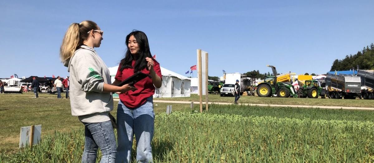 Two FARE students in a field discussing research