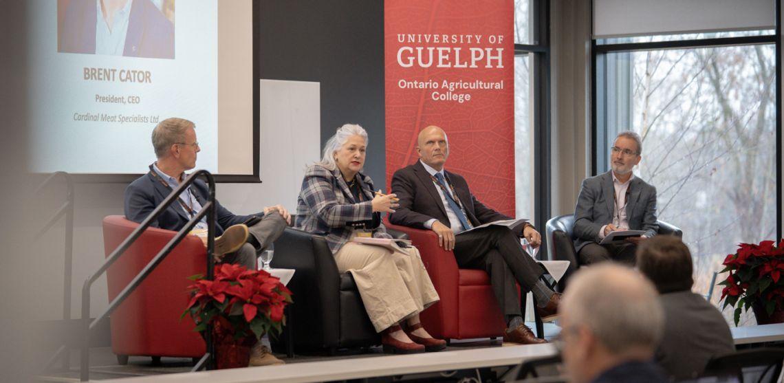 Four guest speakers sit onstage