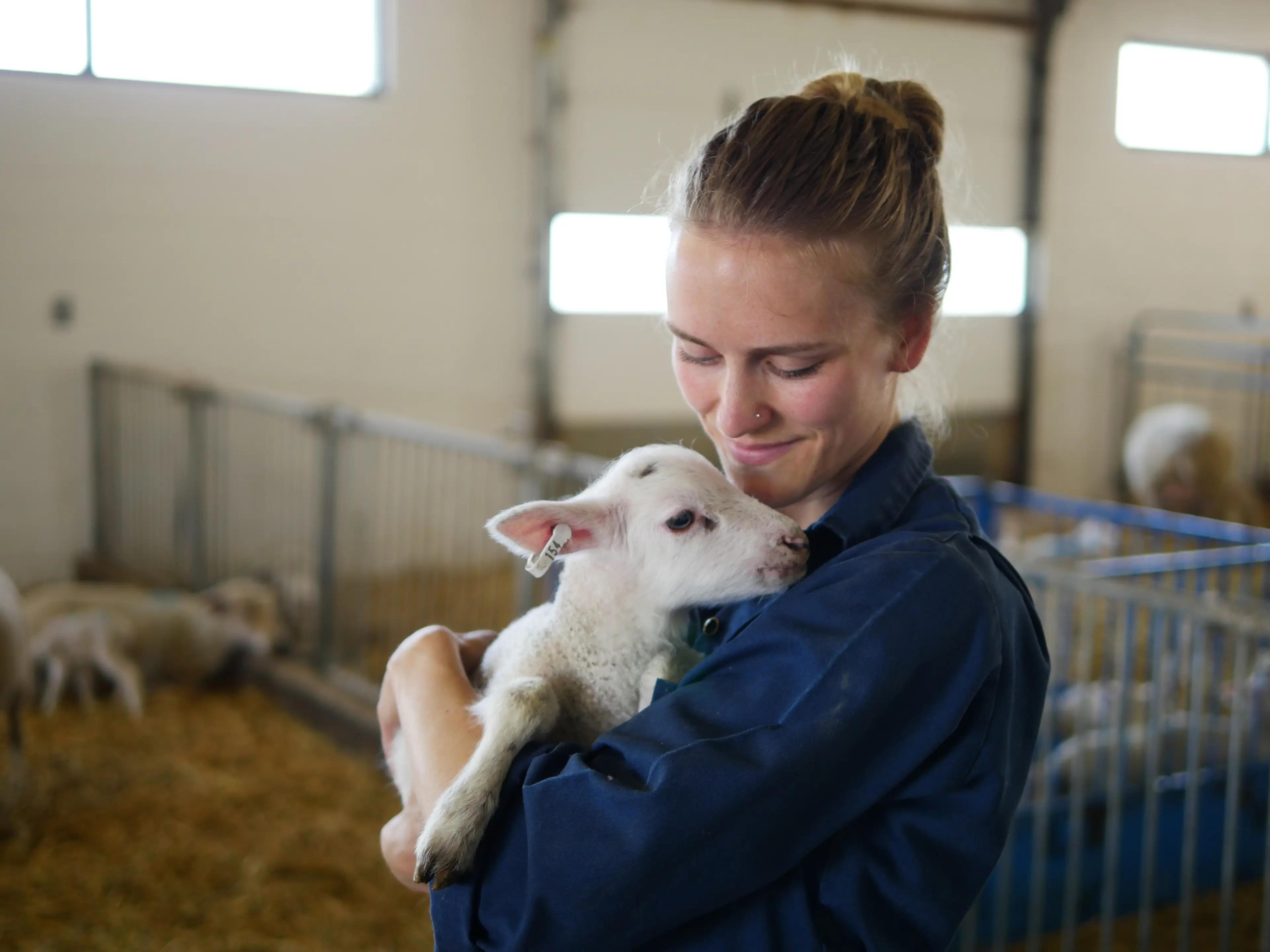 girl holding baby goat