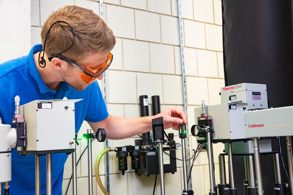 A graduate student works in a lab wearing personal protective equipment at the University of Guelph