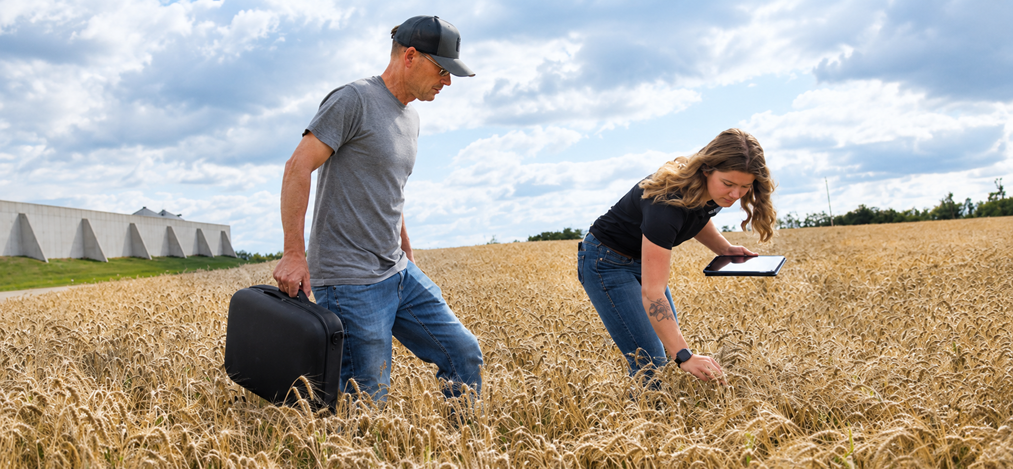 taylor in the field with a farmer