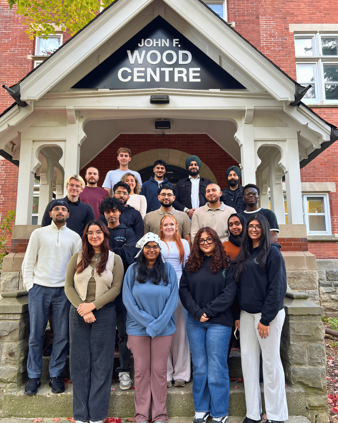 A group of students standing outside smiling at the Camera