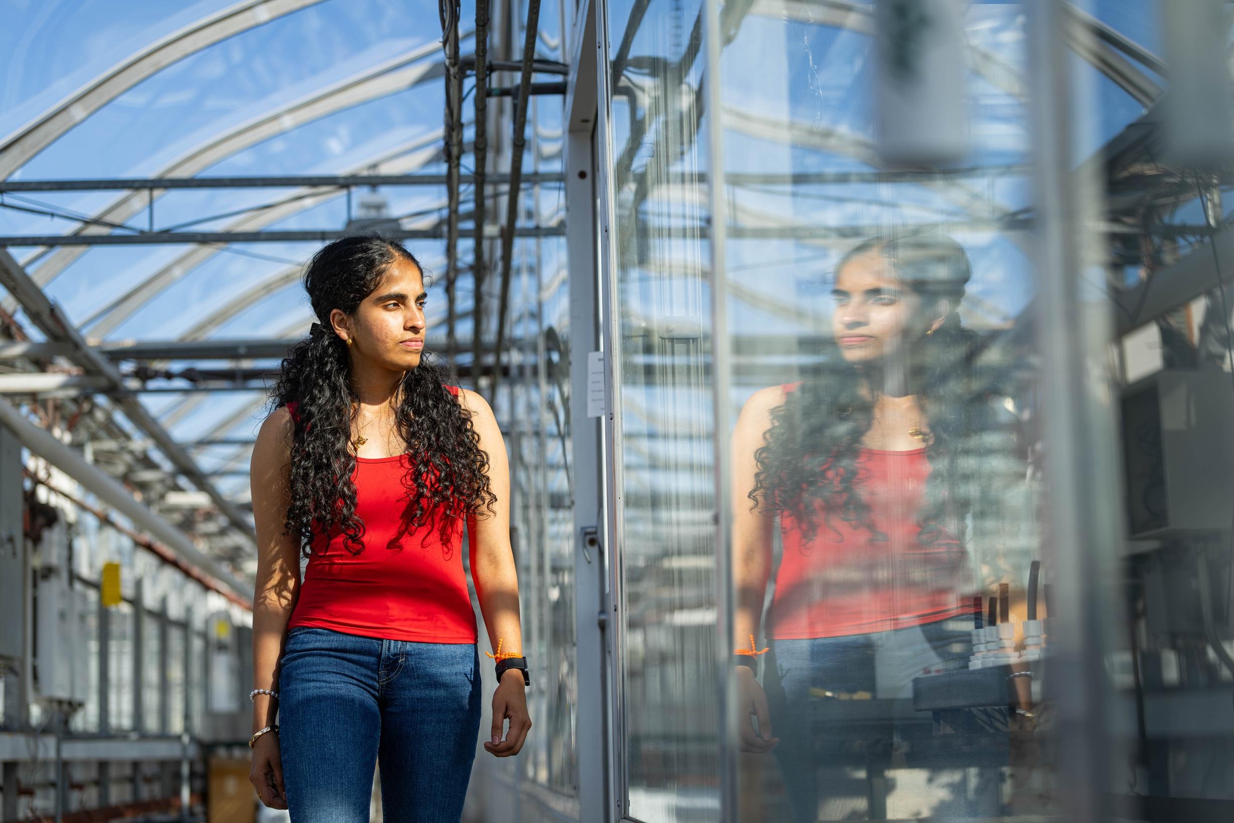 student walking through greenhouse
