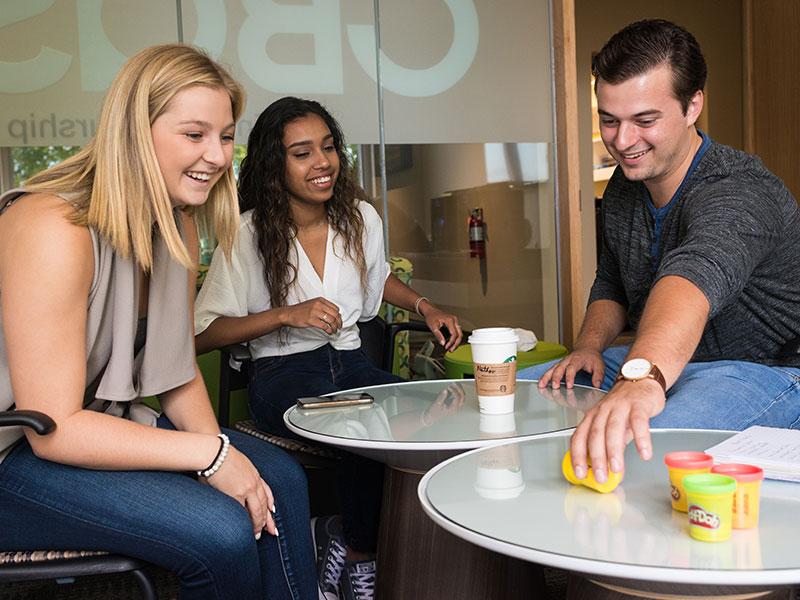 3 University of Guelph students at a cafe playing with play-doh