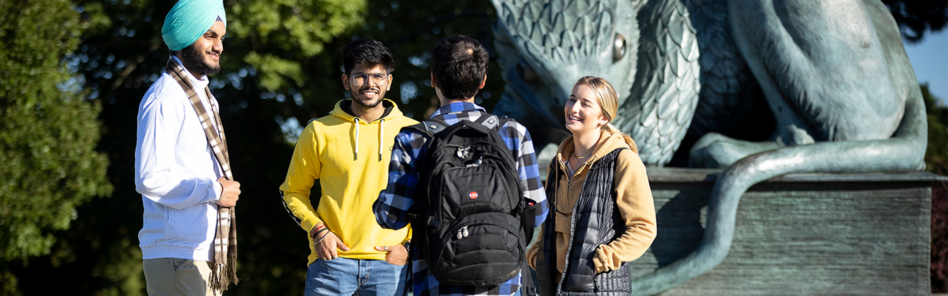 International students chat at the Gryphon Statue