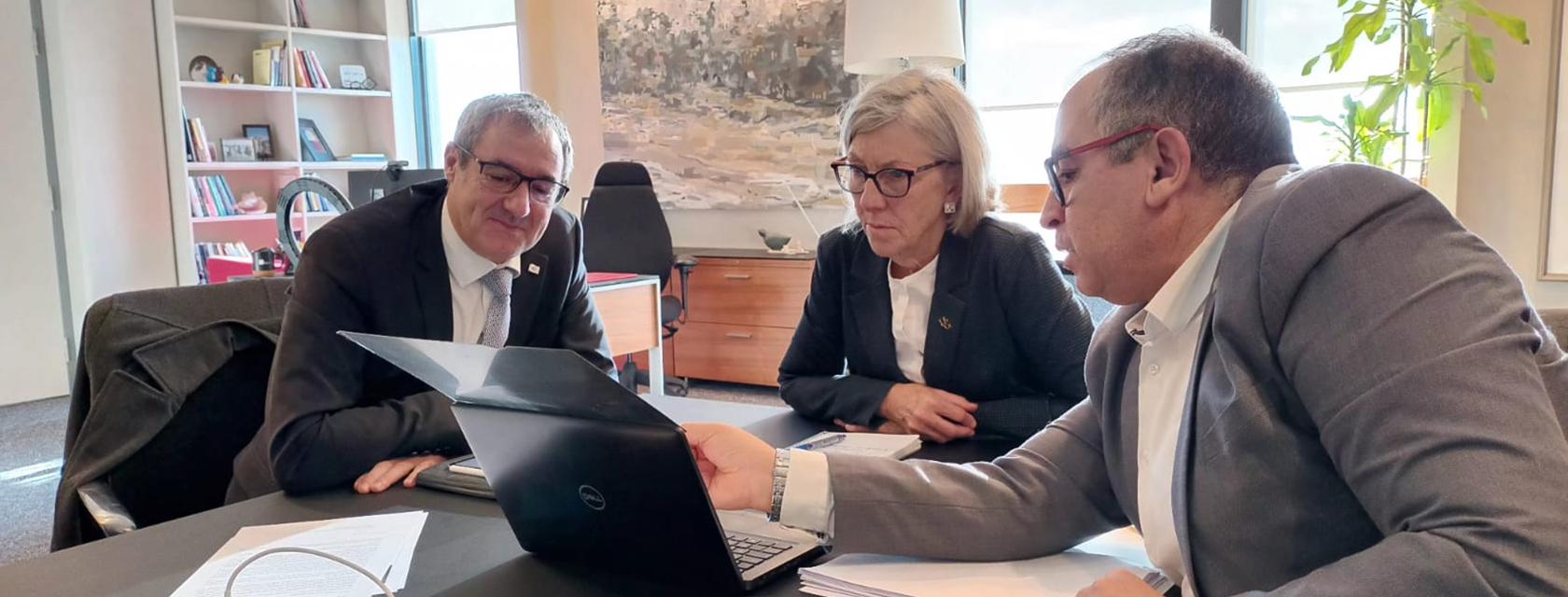 three executives looking at a laptop together