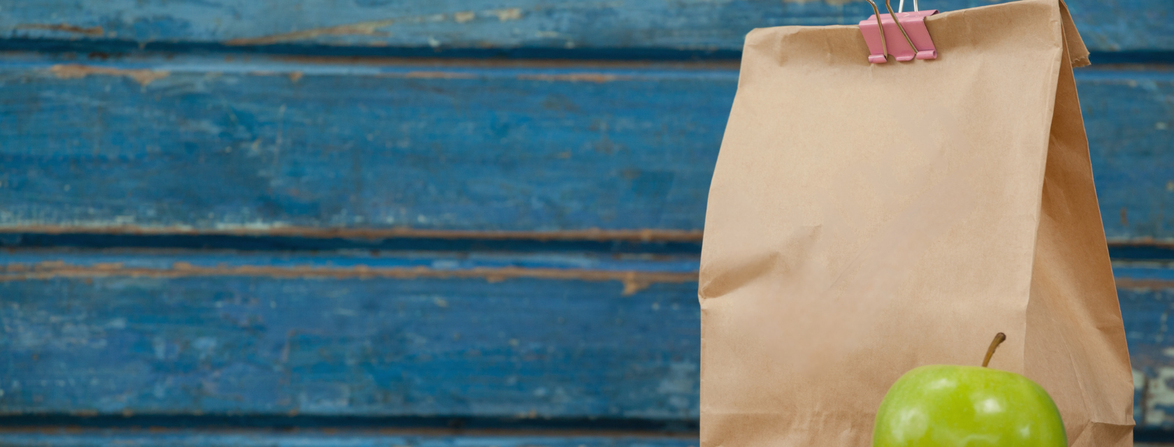 Brown lunch bag with an apple.