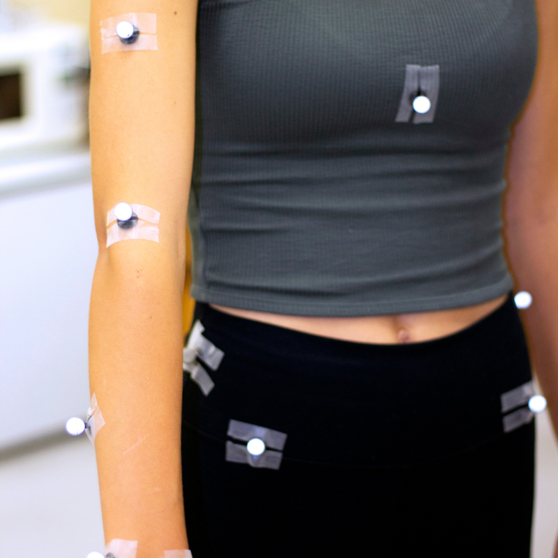 A student displaying her arm adorned with adhesive patches.