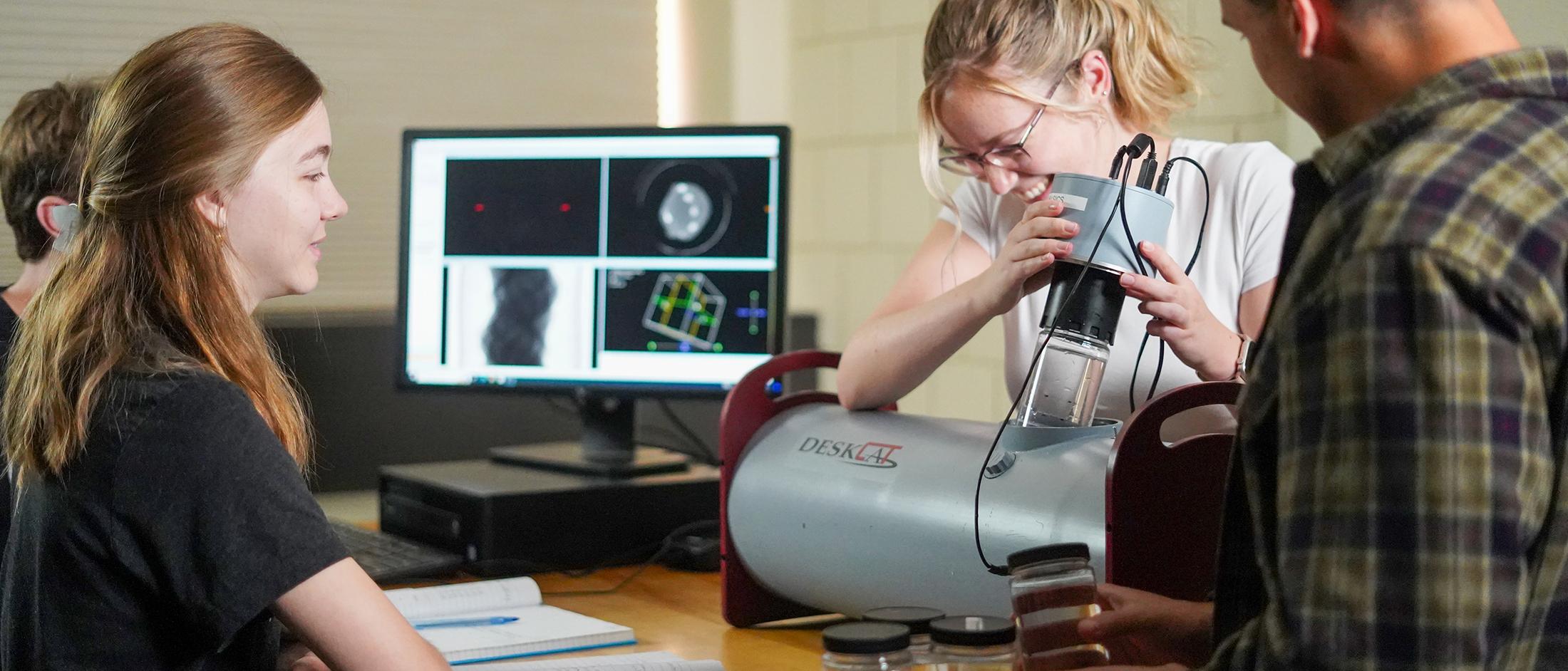 A group of physics students work together in a lab