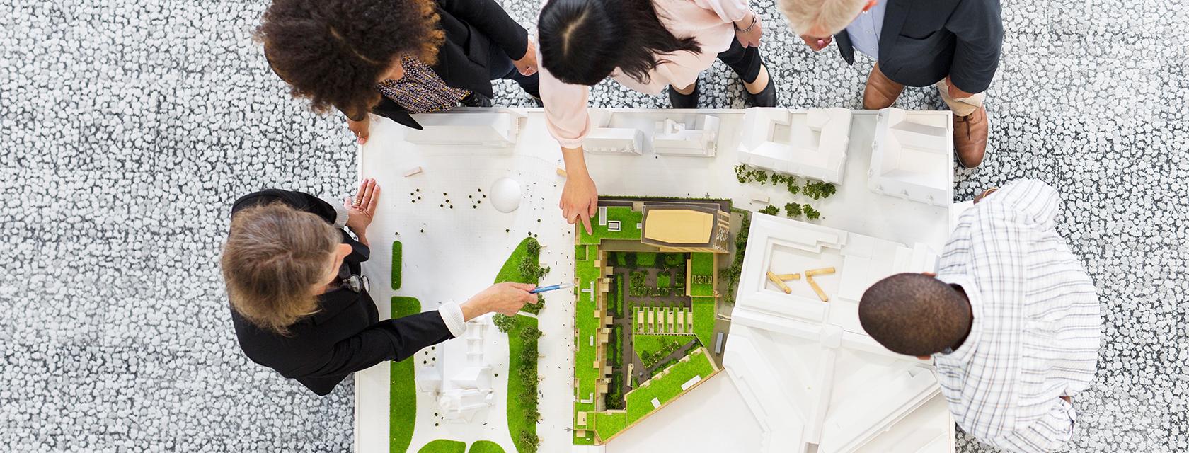 an overhead photo of students looking at a model of a park