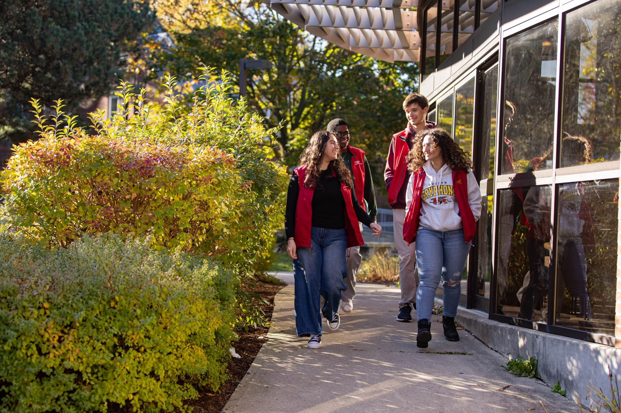 Four Residence Life Staff members in the red vest walking outside the LA residence