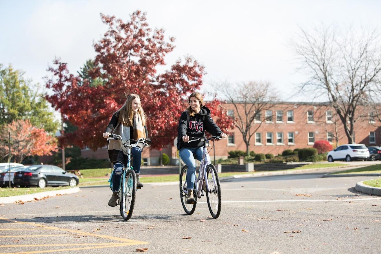 2 students biking on campus