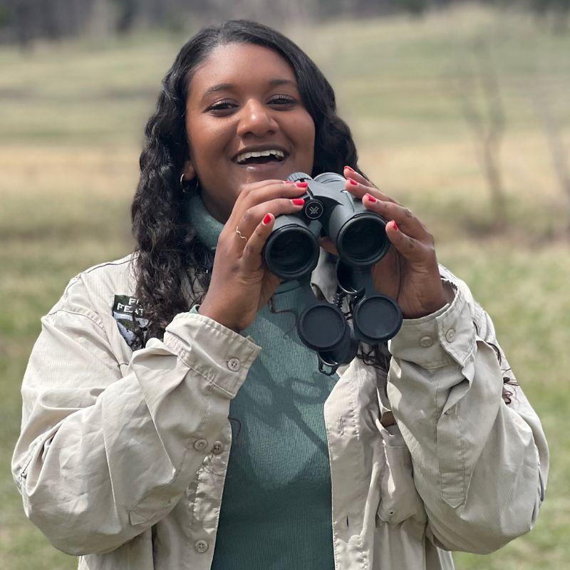 Shanelle looking through a pair of binoculars.