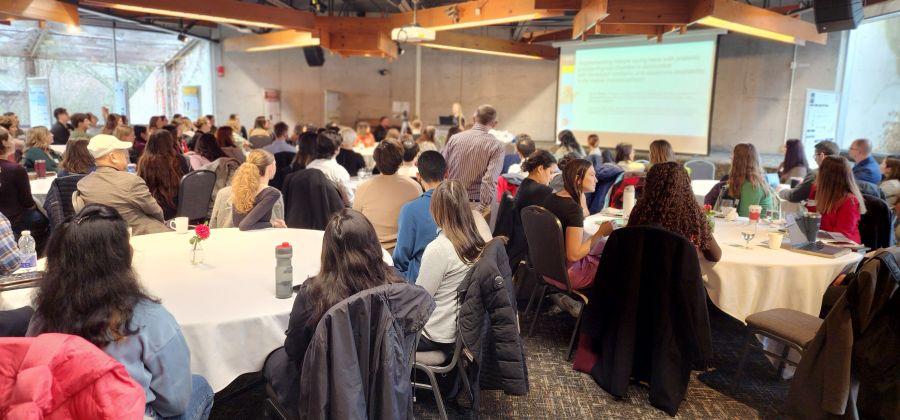 More than 50 people watch a speaker in the large Arboretum conference room at the 2024 Animal Biosciences Symposium