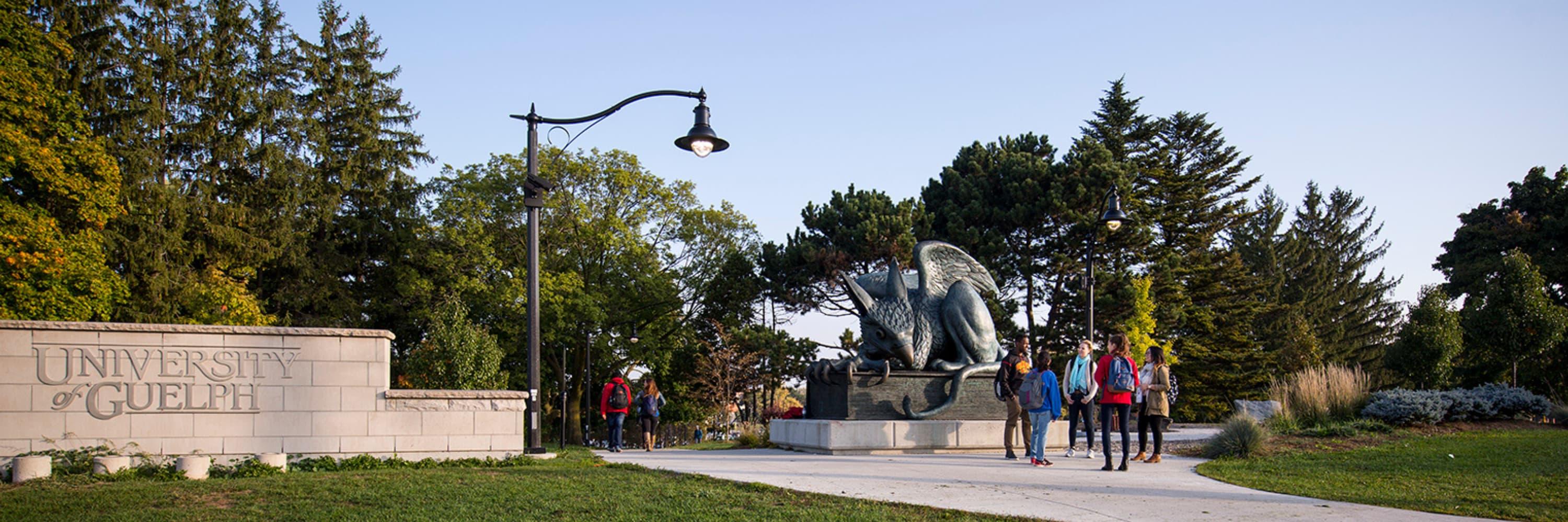 Group of students standing in front of gryphon statue