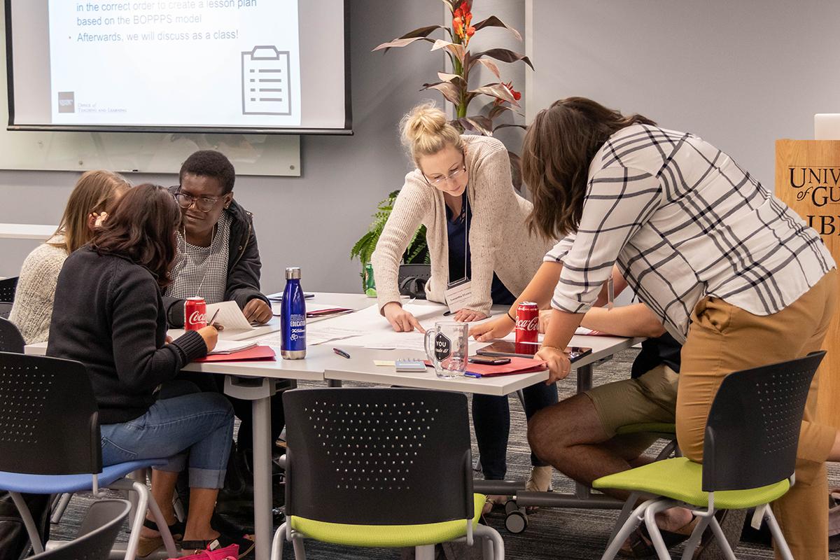 Multiple people at a table working on a paper