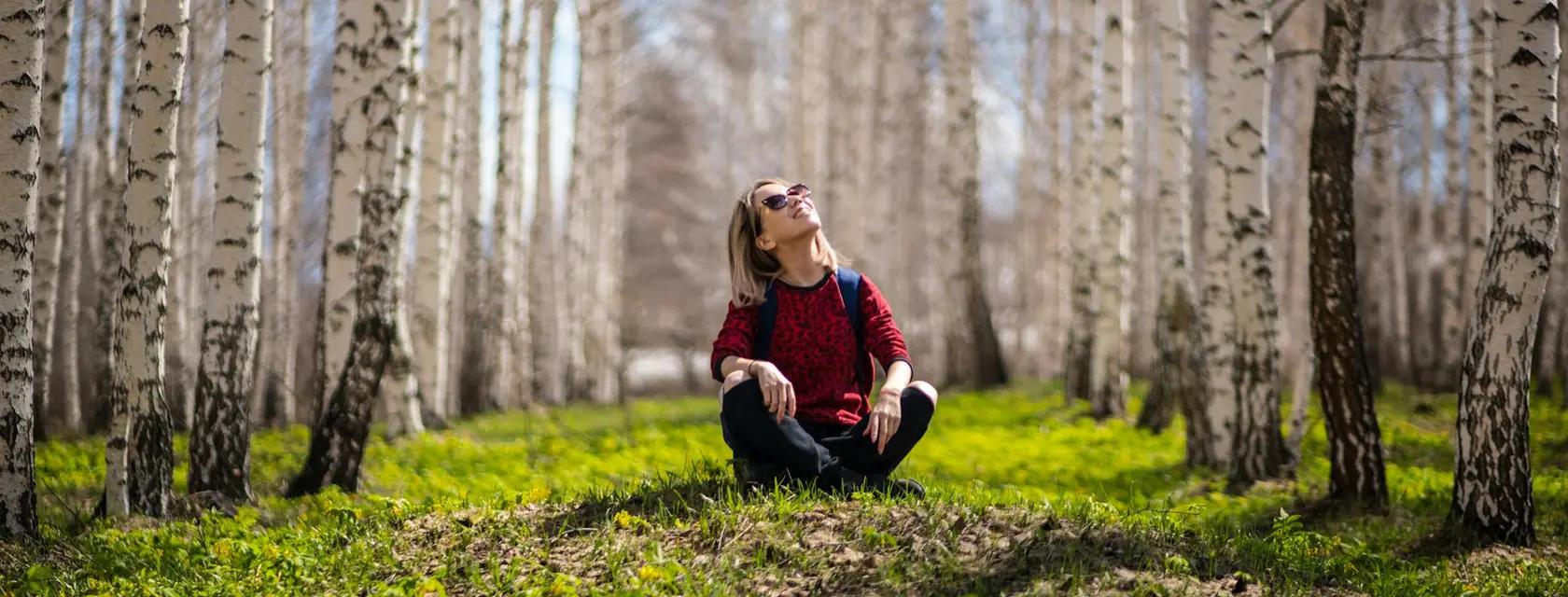 A student enjoys a sunny day in the forest
